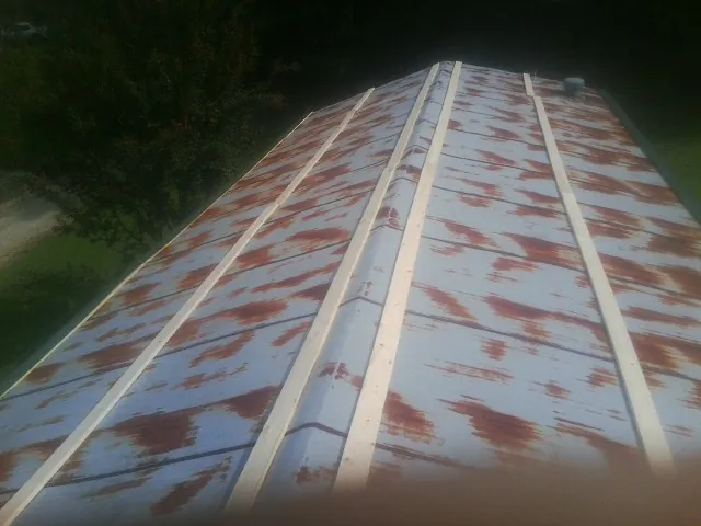 Rusted metal roof panels with new wood purlins before replacement — Storm Damage Roof Repair in Brooks by Roofing Brothers