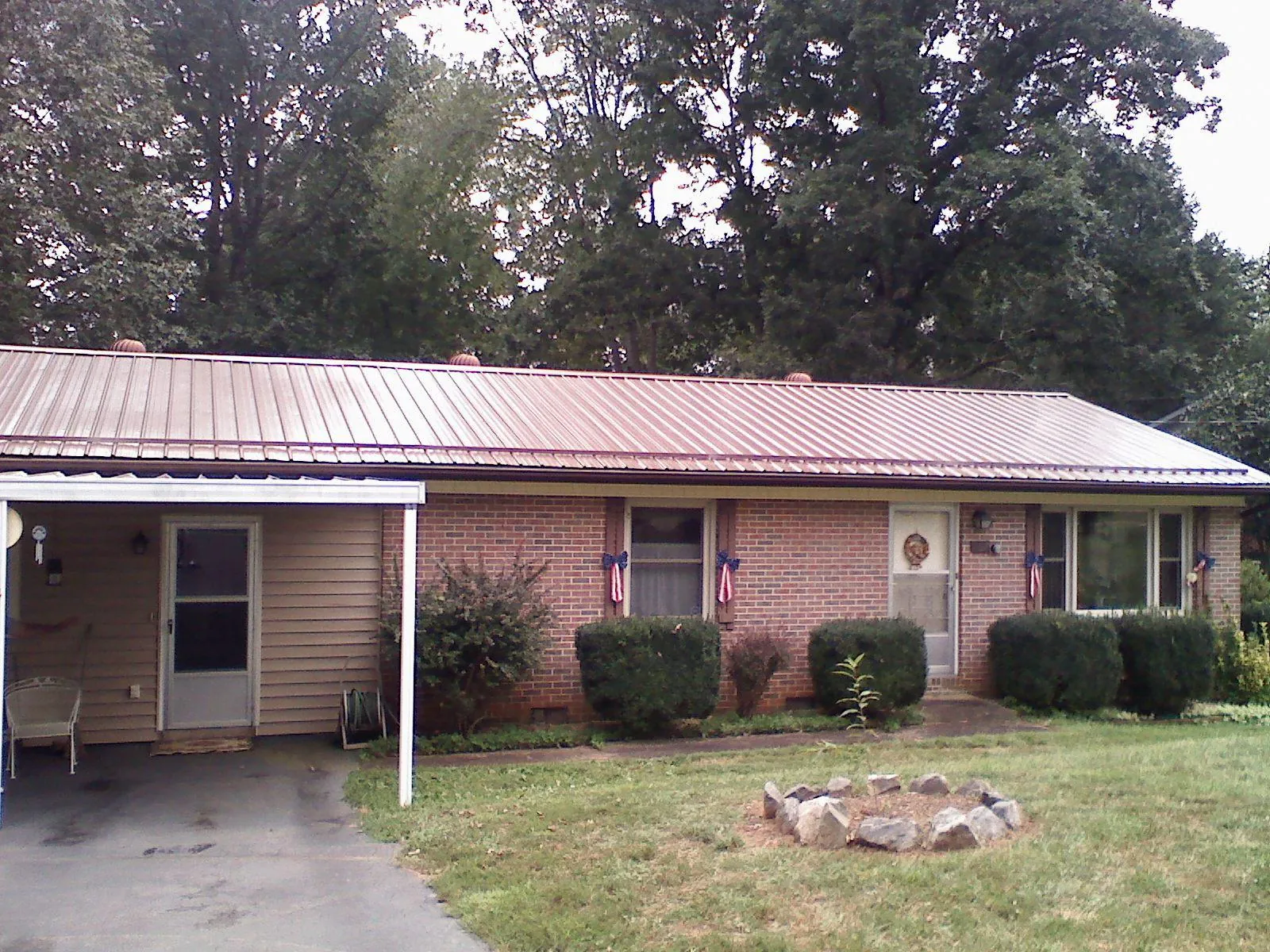 Bronze metal roof and carport on a brick ranch home — Roof Repair work by our crew in Brooks